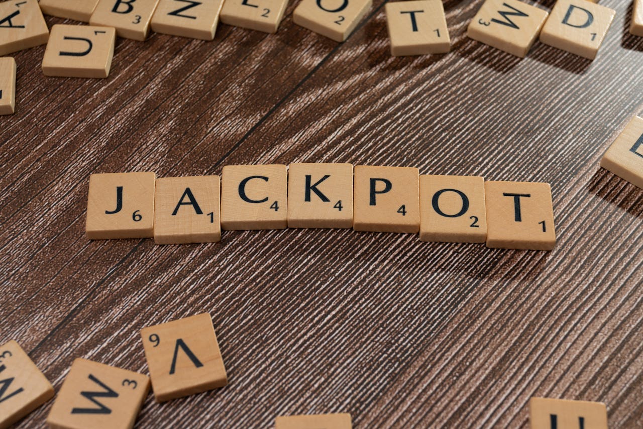 Wooden letter tiles spelling JACKPOT on a textured wooden surface, representing winning or success.